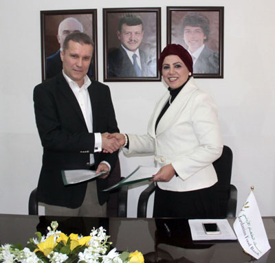 Jordanian Food Bank Executive Director Kawther Qatarneh shakes hands with Jordanian Austrian Company CEO Rashad Garabet after signing a cooperation agreement in Amman on Thursday (Petra photo)